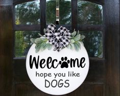 a welcome sign hanging on a door with a dog's name written on it