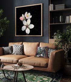 a living room with a couch, coffee table and potted plant on the wall