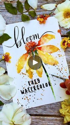 a card with watercolor flowers and the words bloom on it