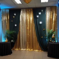 an empty room with gold curtains and black table cloths on the floor, decorated for christmas