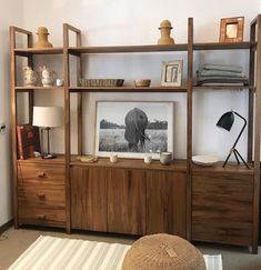 a living room with an elephant photograph on the wall next to a book shelf and lamp