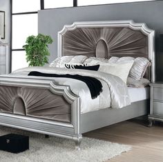 a bedroom with a bed, dressers and mirror in it's center area