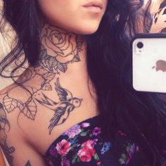 a woman with tattoos is taking a selfie in her cell phone case while she's wearing a floral dress