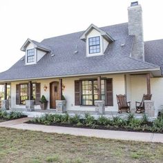 a white house with brown shutters on the front and windows in the back yard