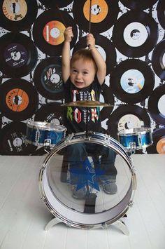 a young boy is playing with some drums