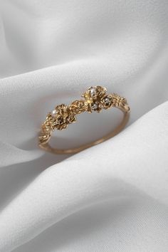 Drops of pearl moonlight, nestled in the most ethereal blooms and plucked from a dream. Hand-carved, with intricately layered unfurling petals of gold. An enchanted heirloom, gracing your finger. Available in 14k yellow, rose, white, or champagne goldOne 8mm seed pearlTwo 1-1.2mm seed pearlsTwo 1.7-1.9mm seed pearls Your piece will be made-to-order—please allow 4 to 6 weeks for us to create the piece before shipping to you. If you require a quarter size or a size not listed on our dropdown menu, Heirloom Jewelry Ideas, Ethereal Wedding Rings, Cottage Core Engagement Ring, Cottage Core Wedding Ring, Cottagecore Wedding Ring, Beautiful Jewelry Vintage, Ethereal Engagement Ring, Whimsical Wedding Ring, Pearl Wedding Rings