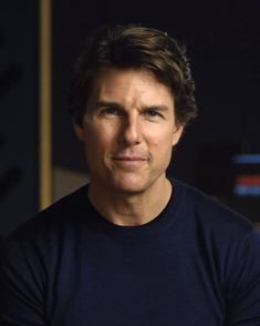 a man in a black shirt is looking at the camera