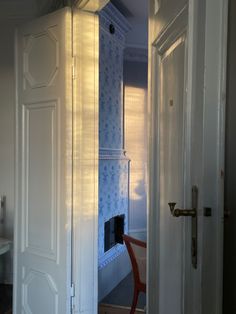 an open door leading to a bathroom with blue wallpaper