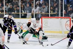 an ice hockey game is being played in front of the crowd and people are watching