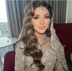 a woman with long hair wearing a veil and jewelry