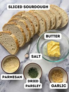 bread, butter, parmesan and garlic on a marble counter top with the words sliced sourdough