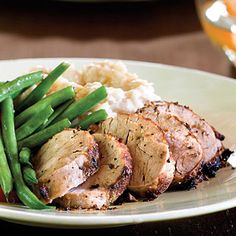 a white plate topped with meat and green beans