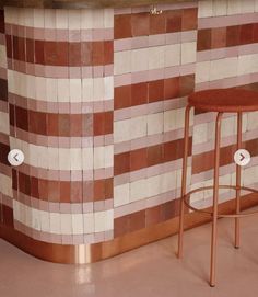 two stools in front of a tiled wall with buttons on the barstools