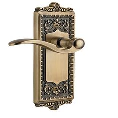 an antique style door handle with ornate design on the front and side panels, in satin stainless