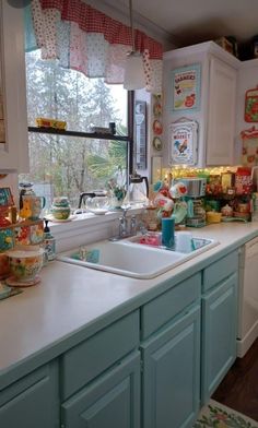 a kitchen filled with lots of clutter next to a sink and counter top under a window