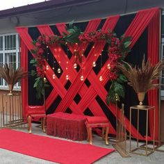 a stage set up with red curtains and flowers