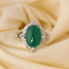 Presenting you a Beautiful Yet Delicate looking Green Onyx Ring, The design is simple with Splited Y shank  accented with oval onyx cabochon along with zircon accents with Four Bigger Zircon on opposing sides to give it a sharp Look. The color of Onyx resembles with of Emerald Green ,for a stance it gives a glimpse of emerald Ring Perfect Gift for birthday, Graduation,Proposal or Promise or One can give a treat to themselves. tem No: skj. 11.598 Item:Natural Green Onyx Minimalise Ring In 925 Sterling Silver Primary stone: Green Onyx Secondary stone:zircon Article Weight: 6.5gms primary stone Size :10x14 mm Ring Length:2.2 cm Ring Width:2cm Maintenance Tips 1.Keep the jewelry away from direct heat, water, perfumes, deodorants, and other strong chemicals.  2.Wipe the Jewellery gently with a Luxury Oval Green Onyx Jewelry, Graduation Proposal, Cabochon Ring, Onyx Ring, Green Onyx, Gift For Birthday, Halo Ring, Emerald Ring, Bridal Gifts