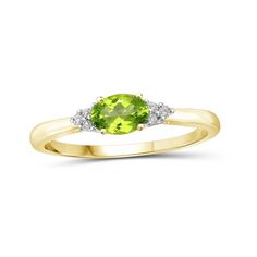 a yellow gold ring with an oval cut peridot and two diamonds on the side