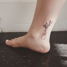 a woman's foot with a flower tattoo on the bottom of her left leg