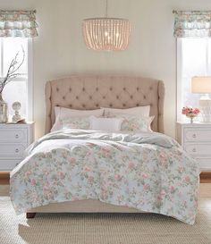 a bedroom with a bed, dressers and two lamps on the side of it