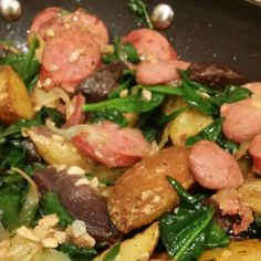 a close up view of some food with meat and spinach leaves on it's side