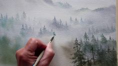 someone is painting a landscape with watercolors