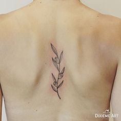 the back of a woman's shoulder with a flower tattoo on it