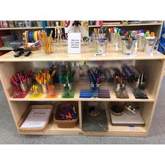 a shelf filled with lots of different colored pens and pencils on top of it