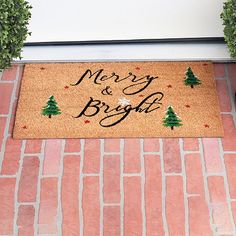 a merry and bright door mat with trees on it