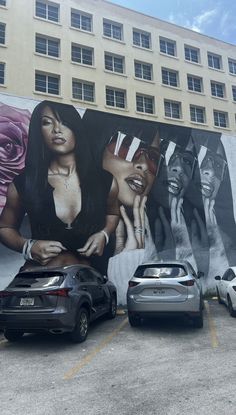 several cars parked in front of a large mural