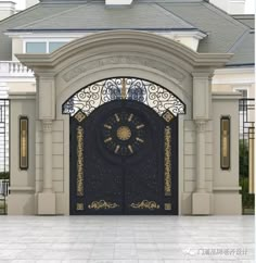 a large black and gold door in front of a white building with an ornate arch