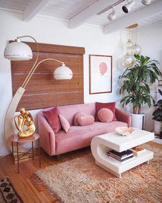 a living room with pink couches and rugs in front of a wooden paneled wall