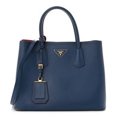 This is an authentic PRADA Saffiano Cuir Small Double Bag in Ink Blue Fire Engine Red. This elegant tote is crafted of beautifully textured cross-grain Saffiano leather in a vibrant blue. It features rolled leather top handles, polished gold-tone hardware, a leather triangle with the Prada logo, a leather hanging ID tag, and expandable snap sides. The top is open to a partitioned red leather interior with a central flap pocket. Blue Epsom Leather Rectangular Bag, Blue Rectangular Epsom Leather Bag, Rectangular Blue Epsom Leather Bag, Blue Epsom Leather Bag With Gold-tone Hardware, Luxury Blue Epsom Leather Bag, Elegant Blue Smooth Grain Bags, Blue Textured Calf Leather Bag, Blue Epsom Leather Top Handle Bag, Luxury Blue Calf Leather Bag