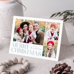 a christmas card with three photos on it next to some pine cones and other holiday decorations