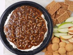 a plate with crackers, apple slices and dip