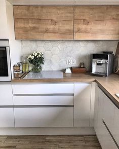 a kitchen with white cabinets and wooden counter tops, along with a microwave on the wall