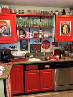 a kitchen with red cabinets and shelves filled with coca - cola bottles, cups, and other items