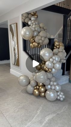 a bunch of balloons that are in the shape of a spiral staircase with gold and silver balls on it