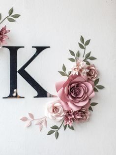 the letter k is surrounded by paper flowers