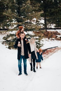 a family walking in the snow holding hands