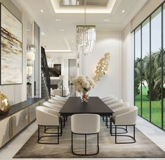 an elegant dining room with large windows and chandelier hanging from the ceiling, along with white chairs