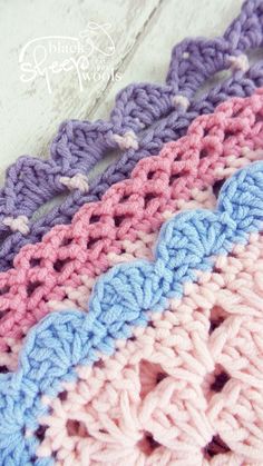 three crocheted afghans with different colors and patterns on the bottom one is blue, pink, purple, and white