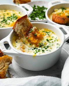 several bowls of soup with bread and garnishes on the side, ready to be eaten