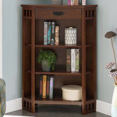 a bookshelf with many books on it in the corner of a living room