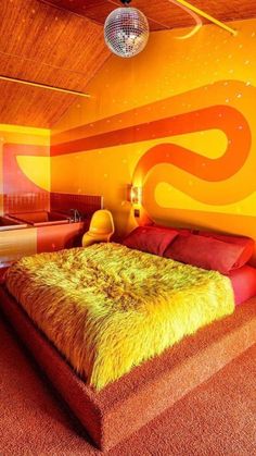 a bedroom with an orange and yellow color scheme on the walls, carpeted floor, and bed