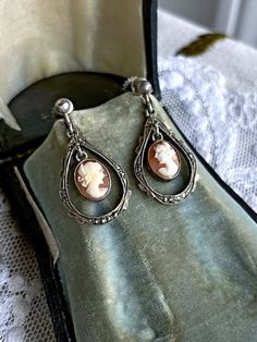 Featuring a beautiful pair of demure antique Victorian stamped 800 silver screw back dangle  earrings adorned with luminous genuine carved Conch Shell Cameos set in open back pronged settings.  Earrings measure approximately 1.5  inches long at 5. grams respectively.  Both pieces are in excellent antique condition with functional backs, a beautiful patina with all components intact and accounted for.  Stamped 800 on the reverse of both earrings these a just beautiful! An investment worth wearing Vintage Sterling Silver Clip-on Earrings, Vintage White Gold Dangle Jewelry, Vintage Cameo Round Earrings, Antique Silver Vintage Dangle Jewelry, Antique Dangle Earrings, Vintage Antique Silver Dangle Jewelry, Vintage Antique Silver Dangle Earrings, Victorian Engraved Drop Earrings, Vintage Sterling Silver Dangle Jewelry