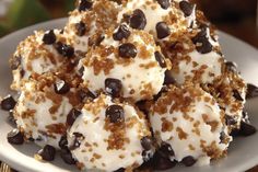 a white plate topped with chocolate chip cookie doughnuts covered in whipped cream and chocolate chips