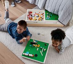 two children playing with legos on the floor