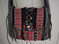 a purse hanging on the side of a door with buttons and beads attached to it