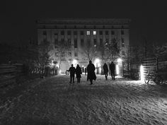 people are walking in the snow at night